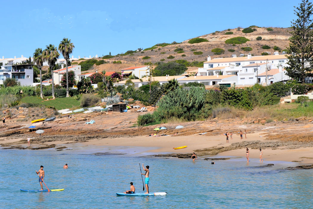 The view from the sea to Ocean Villas Luz sees happy people out on stand up paddleboards or relaxing on Prainha beach