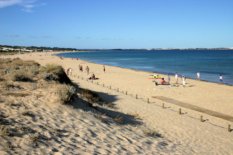 Meia Praia has sand dunes that fringe the edges and look pretty against a backdrop of blue skies and blue sea