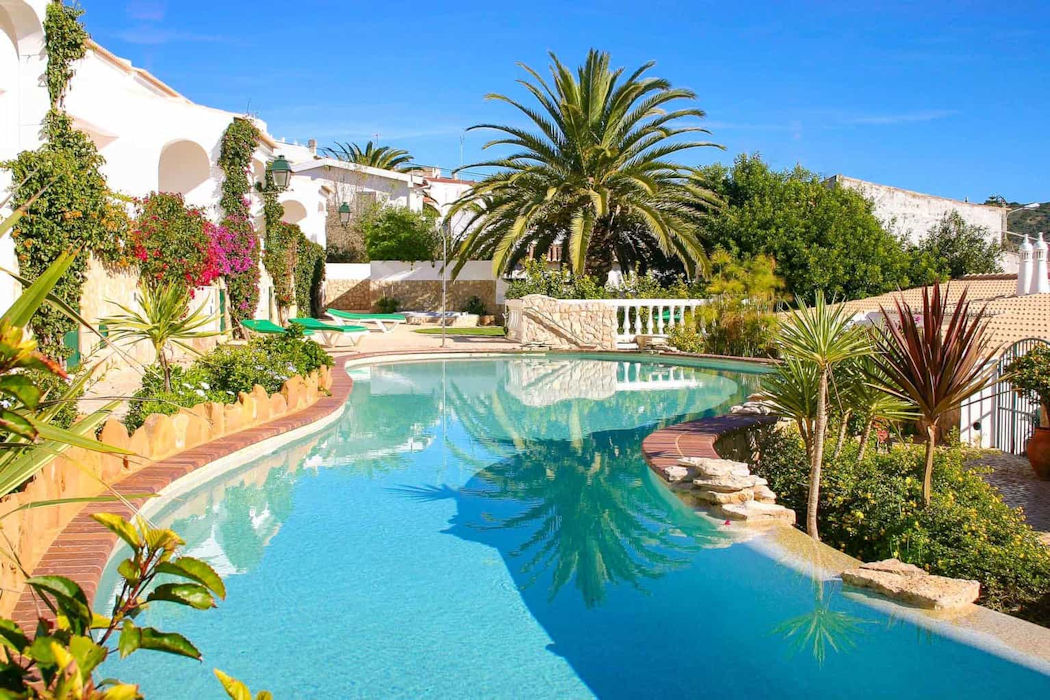 The 21m lagoon style swimming pool looks terrific surrounded by palm trees and the white villas