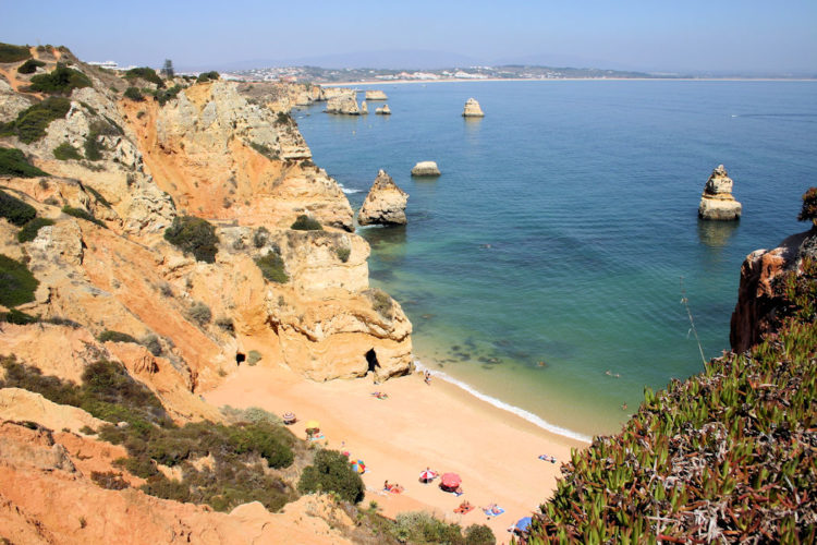 An aerial shot of the sandstone cliffs and clear waters at Do Camilo beach make it one of the Algarve's best