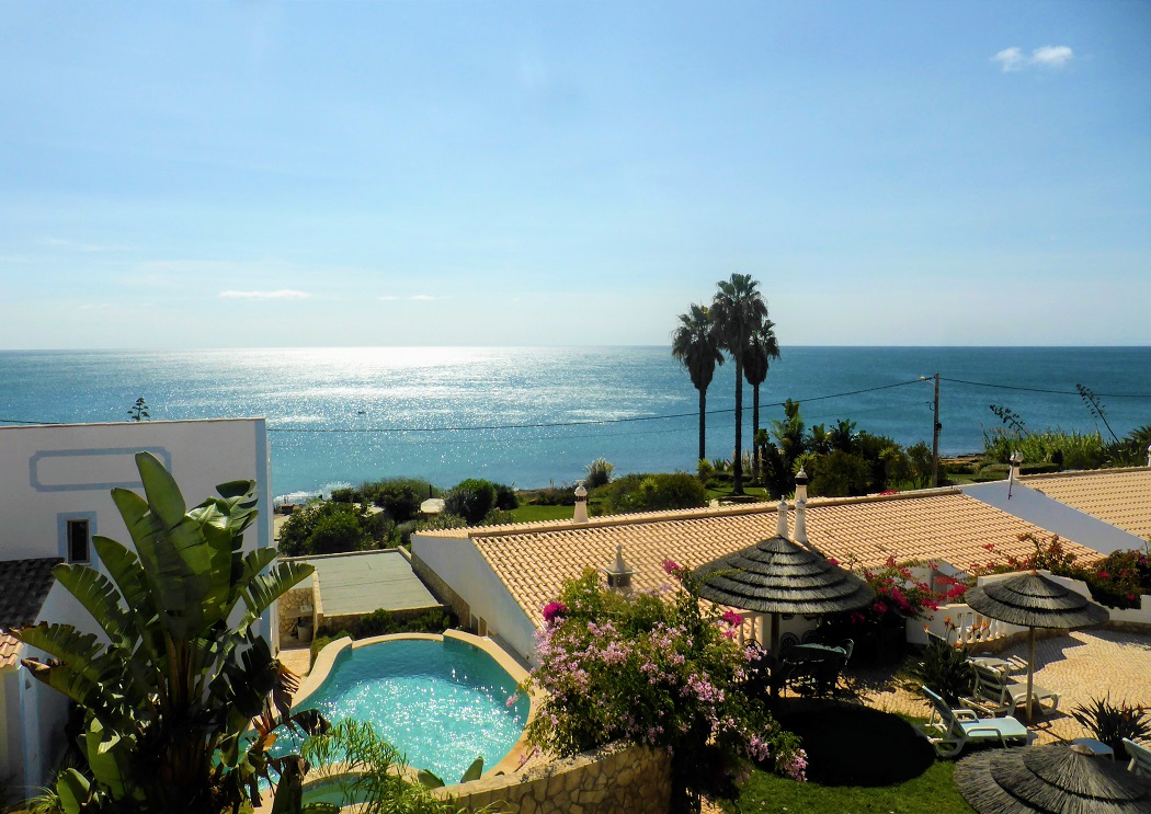 The panorama from a one bedroom apartment towards shimmering blue waters and lush green gardens.