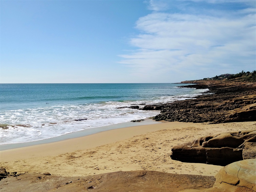 A peaceful scene of the golden sand and blue seas on Prainha, Praia da Luz.